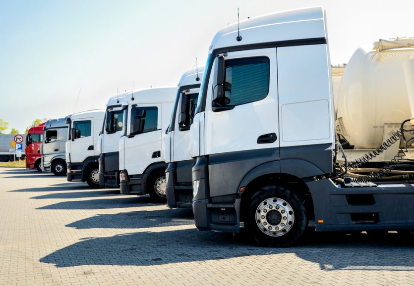 Group,Of,White,Trucks,Parked,At,Parking,Lot.,Vehicles,Parked